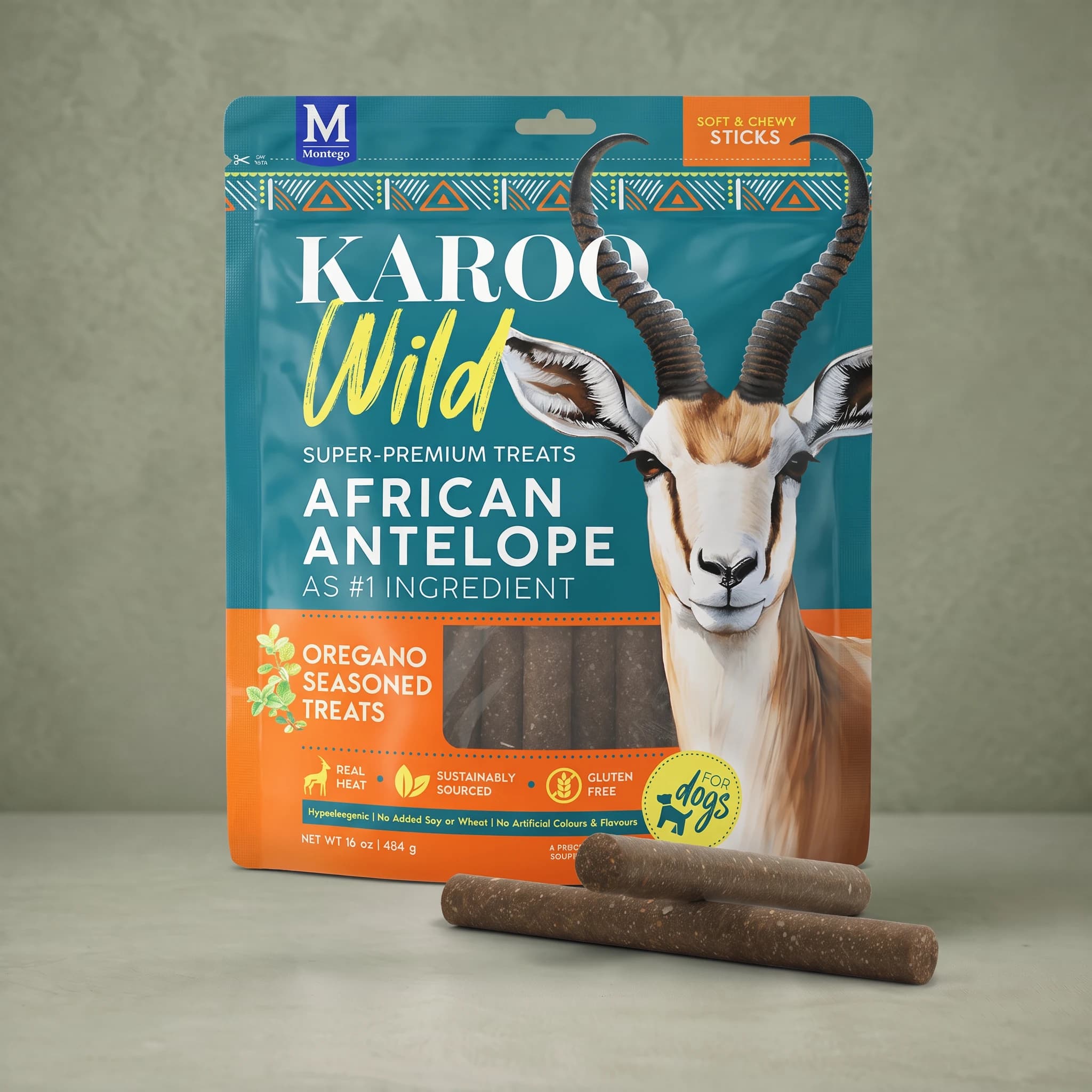 The same teal and orange Karoo Wild Oregano Sticks pouch standing upright against a plain sage green background, with two dark brown chewy sticks crossed at its base.