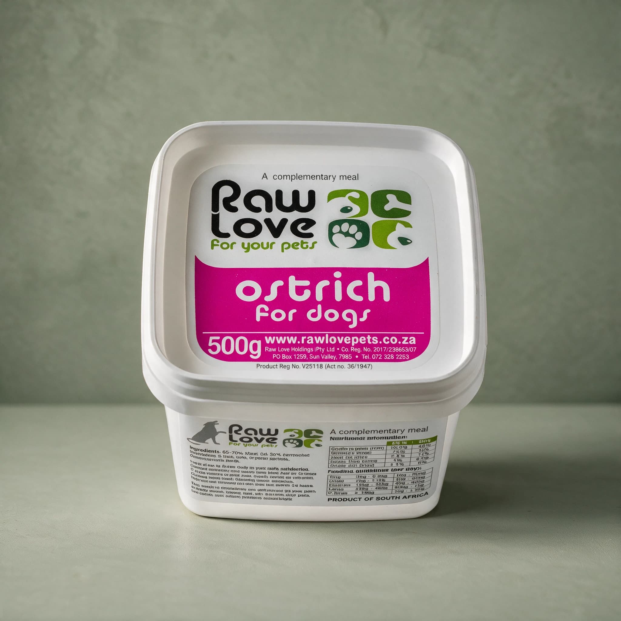 White 500g tub of Raw Love Ostrich for Dogs raw frozen food, with the Raw Love logo and the words 'A complementary meal', photographed against a sage green background.