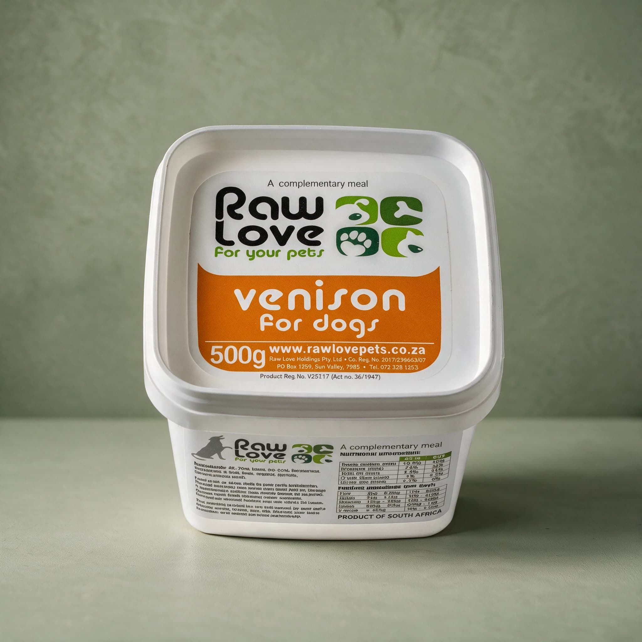 White 500g tub of Raw Love Venison for Dogs raw frozen food, with the Raw Love logo and the words 'A complementary meal', photographed against a sage green background.