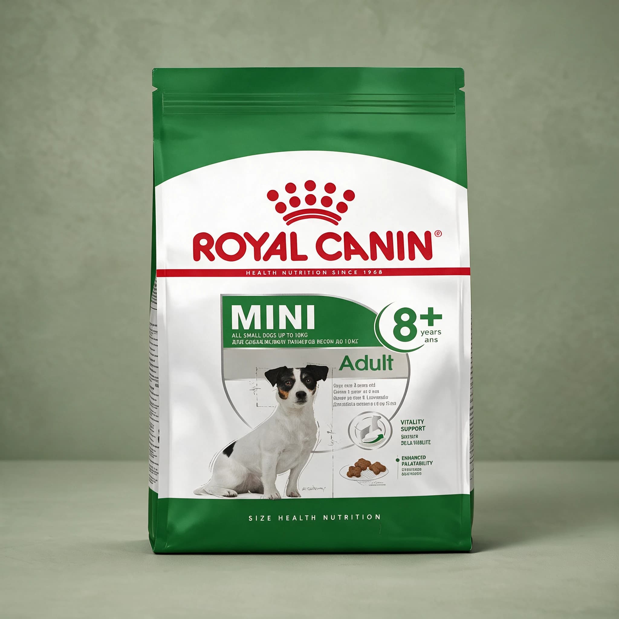 The grey and white Royal Canin Mini Adult 8+ dry dog food bag, featuring a small tan-and-white terrier illustration and "Vitality Support" callout, photographed against a plain sage green studio background.